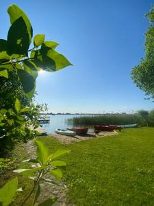 a group of boats on the shore of a lake at Czerwony domek nad samym jeziorem in Mikołajki