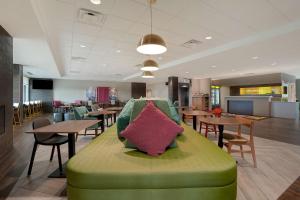 a green couch with a pillow on it in a restaurant at Home2 Suites By Hilton Lakewood Ranch in Bradenton