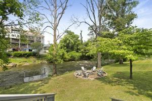 a backyard with a table and chairs next to a river at Mill Stream Cottage in Pigeon Forge