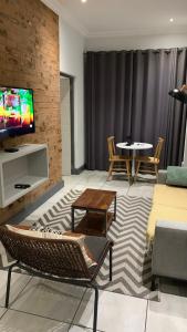 sala de estar con sofá, sillas y TV en CALDESMO Private Apartment en Pretoria