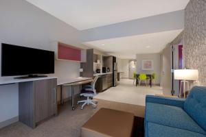 a living room with a blue couch and a tv at Home2 Suites By Hilton Lakewood Ranch in Bradenton