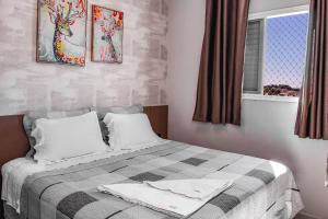 a bedroom with a bed with two pillows and a window at Acomodação Extraordinária em sua viagem - LoftFelau in Cuiabá