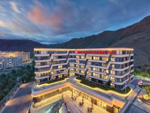 Hilton Garden Inn Lhasa في لاسا: اطلالة جوية على فندق فيه جبال في الخلفية