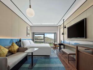 拉薩的住宿－拉萨天峰希尔顿花园酒店，酒店客房配有床、沙发和电视。