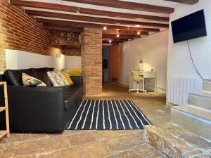 a living room with a couch and a brick wall at Duplex de encanto en Part Alta! in Tarragona