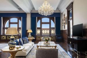 a living room with a couch and a chandelier at Waldorf Astoria Washington DC in Washington, D.C.