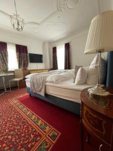 1 dormitorio con 1 cama y 1 mesa con lámpara en Hotel Garni Ratstube en Bad Urach