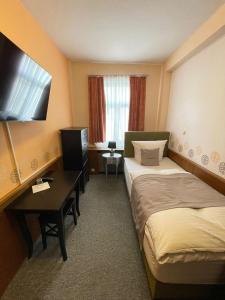 a hotel room with two beds and a desk at Hotel Garni Ratstube in Bad Urach