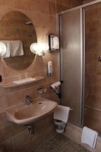 a bathroom with a sink and a shower at Hotel Garni Ratstube in Bad Urach