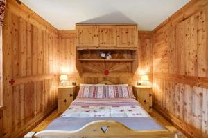 una camera da letto con pareti in legno e un letto interno di Maison Grange 1 a Gressan