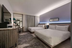 a hotel room with two beds and a television at The Morrow Washington Dc, Curio Collection By Hilton in Washington, D.C.