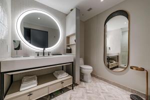 a bathroom with a sink and a mirror and a toilet at The Morrow Washington Dc, Curio Collection By Hilton in Washington, D.C.