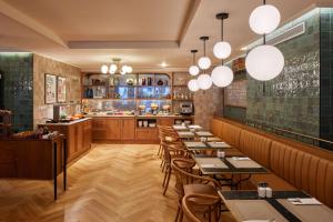 a restaurant with tables and chairs and a bar at Via Sants Hotel Barcelona, Tapestry Collection By Hilton in Barcelona