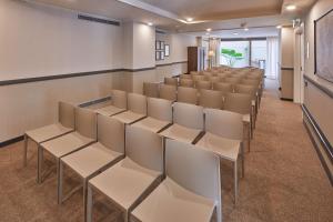 a lecture room with white chairs and a podium at Via Sants Hotel Barcelona, Tapestry Collection By Hilton in Barcelona