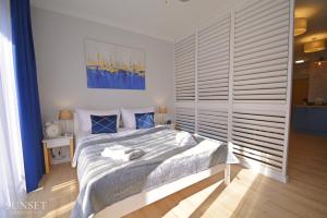 sypialnia z łóżkiem i dużym oknem w obiekcie Sunset Apartments - Kormoran - Plaża 300m w Świnoujściu
