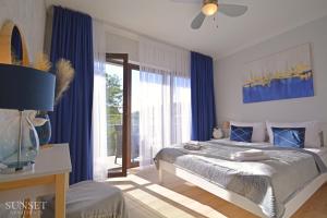 sypialnia z łóżkiem i dużym oknem w obiekcie Sunset Apartments - Kormoran - Plaża 300m w Świnoujściu