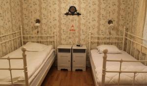 two twin beds in a room with wallpaper at Skillingaryds Gård in Skillingaryd