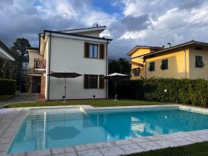 una villa con piscina di fronte a una casa di Villa Anna with pool and lift a Capannori