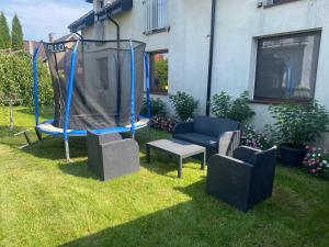 a yard with a gazebo and chairs in the grass at Pokoje na Wczasowej w Sztutowie in Sztutowo