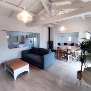 uma sala de estar com um sofá, uma mesa e uma cozinha em Jolie Villa à 400m des plages de sable em La Plaine-sur-Mer