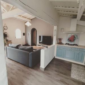 Una sala de estar con un sofá y una cocina. en Jolie Villa à 400m des plages de sable, en La Plaine-sur-Mer