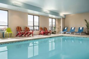 a swimming pool with chairs and a table at Home2 Suites By Hilton Colorado Springs I-25 Central in Colorado Springs