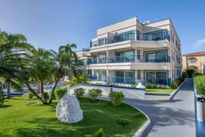 a large white building with palm trees in front of it at Hilton Vacation Club Flamingo Beach Sint Maarten in Simpson Bay