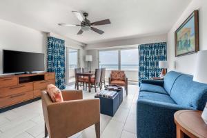 a living room with a blue couch and a tv at Hilton Vacation Club Flamingo Beach Sint Maarten in Simpson Bay