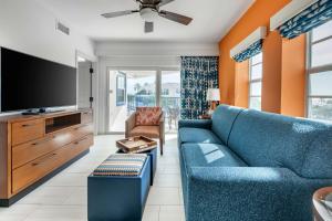 a living room with a blue couch and a flat screen tv at Hilton Vacation Club Flamingo Beach Sint Maarten in Simpson Bay