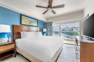 um quarto com uma cama grande e uma varanda em Hilton Vacation Club Flamingo Beach Sint Maarten em Simpson Bay