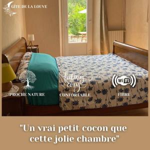 uma cama com um edredão azul e branco em L'ourse, chambre double - Gîte de la Louve em Fougax-et-Barrineuf