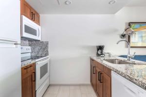 a kitchen with white appliances and wooden cabinets at Hilton Vacation Club Flamingo Beach Sint Maarten in Simpson Bay