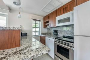 a kitchen with white appliances and wooden cabinets at Hilton Vacation Club Flamingo Beach Sint Maarten in Simpson Bay
