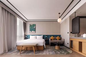 a hotel room with a bed and a tv at Hilton Garden Inn Hefei Binhu New District in Hefei