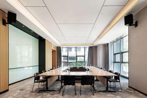 una sala de conferencias con una mesa grande y sillas en Hilton Garden Inn Hefei Binhu New District, en Hefei