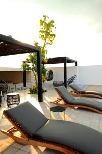 a group of lounge chairs on a patio at Spacious Studio, incredible rooftop with sea view in Playa del Carmen