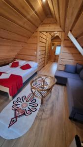 a bedroom with a bed and a couch in a log cabin at Pokoje u Celinki in Szczawnica
