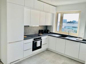 cocina blanca con armarios blancos y ventana en New & Large 1 bedroom in Center-Terrace & Parking - 142-100, en Luxemburgo