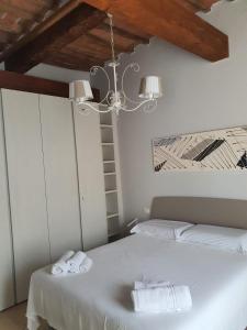 um quarto com 2 camas e um lustre em Mossotti Street Apartment em Pisa