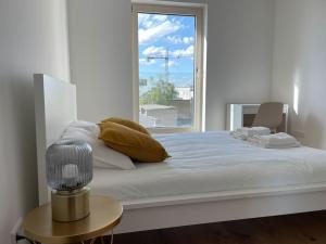 1 dormitorio blanco con 1 cama grande y ventana en New & Large 1 bedroom in Center-Terrace & Parking - 142-100, en Luxemburgo