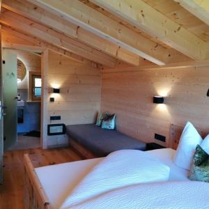 a bedroom with a bed in a wooden cabin at Almchalet Wieslhütte in Gerlosberg