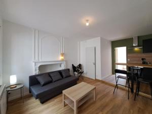 a living room with a couch and a table at Milan - Au milieu des Maisons de Champagne in Reims