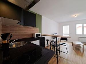 eine Küche mit einer Theke und einigen Stühlen in einem Zimmer in der Unterkunft Milan - Au milieu des Maisons de Champagne in Reims