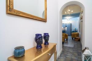 a room with blue vases on a wooden table with a mirror at A Ugghia- I Mori in Fiumefreddo di Sicilia