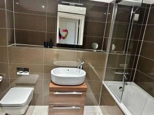 a bathroom with a sink and a toilet and a shower at Modern 1bedflat Kensington in London