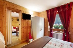 a bedroom with a bed with red curtains and a window at Maison Grange 2 in Gressan