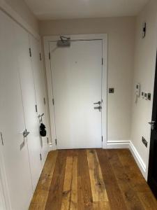 una camera con una grande porta bianca e un pavimento in legno di Modern 1bedflat Kensington a Londra