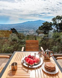 un tavolo con un piatto di frutta e frittelle di Apartamento Vista del Valle en San Antonio de Escazu 