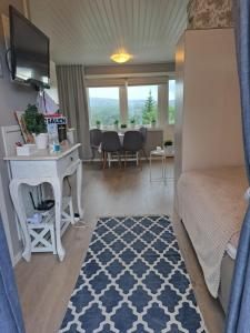 Mysig lägenhet med fjällutsikt i Sälen في سالن: غرفة نوم بسرير ومكتب وطاولة