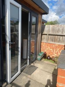 una puerta corredera de cristal abierta de una casa en Cabin Retreat in the heart of Warwick., en Warwick